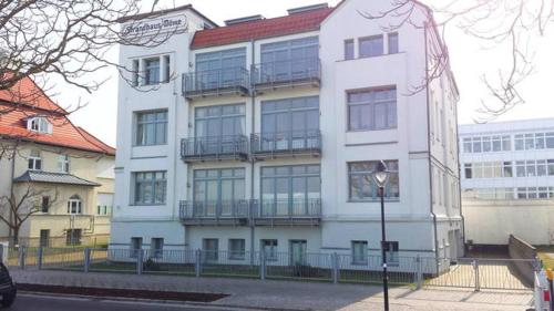 瓦尔内明德Ferienwohnung Warnemünde - L (N)的街道边带阳台的白色建筑