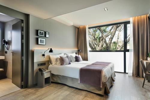 巴塞罗那对角线之上酒店的一间卧室设有一张大床和一个大窗户
