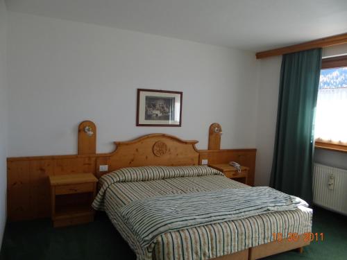 塞尔瓦迪卡多雷蒙德瓦尔酒店的一间卧室配有一张带木制床头板的床和窗户。
