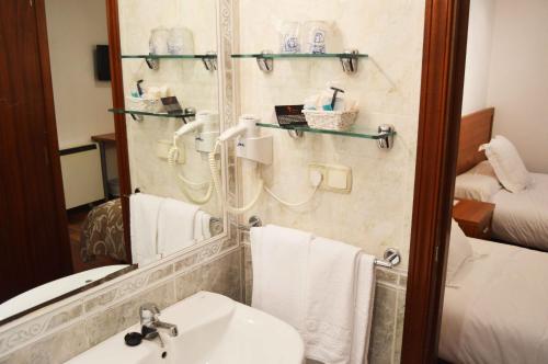 圣地亚哥－德孔波斯特拉Pensión Residencia Fornos的一间带水槽和镜子的浴室