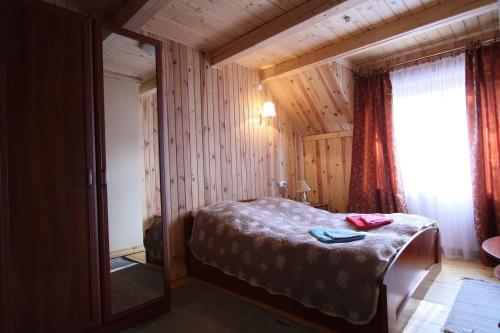 斯拉夫西克Blizzard的卧室配有一张床铺,位于带木墙的房间内