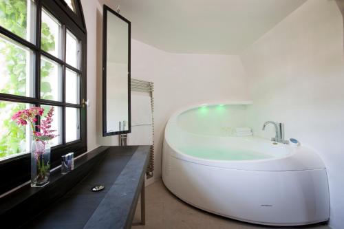 埃特勒塔圣克莱尔 - 第戎地区酒店的带窗户的浴室内的白色浴缸