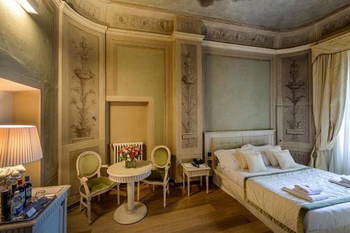 佛罗伦萨奎恰尔迪尼宫殿酒店的卧室配有一张床和一张桌子及椅子