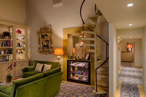 佛罗伦萨奎恰尔迪尼宫殿酒店的客厅配有绿色沙发和镜子