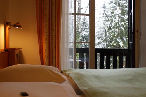 克拉根福斯维瑟豪斯酒店餐厅的一间卧室设有两张床和一个美景窗户。