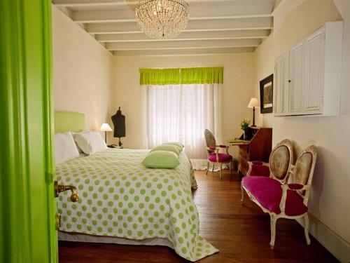 利马金塔米拉弗洛雷斯精品酒店的一间卧室配有一张床、椅子和吊灯