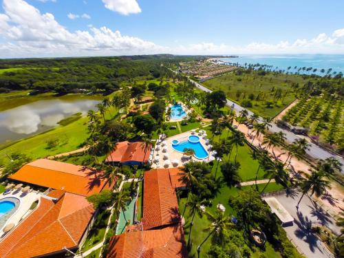 帕里普埃拉Fazenda Fiore Resort的享有带游泳池和海洋的度假村的空中景致
