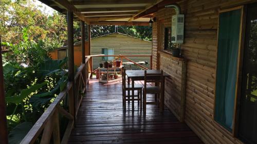 安加罗阿阿基科山林小屋的小屋的门廊配有桌椅