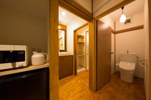 东京希娜一平酒店的一间带卫生间的浴室和位于柜台上的微波炉