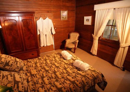 Kurrajong冬宫小屋住宿加早餐旅馆的一间卧室配有一张床、梳妆台和椅子