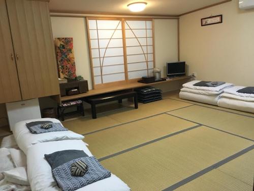 熊本玉木旅馆的一间设有两张床和电视的房间
