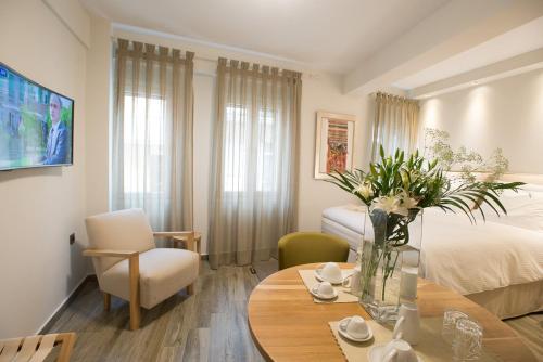 约阿尼纳维列尔民尼别墅旅馆的一间房间,里面设有一张床和一张鲜花桌