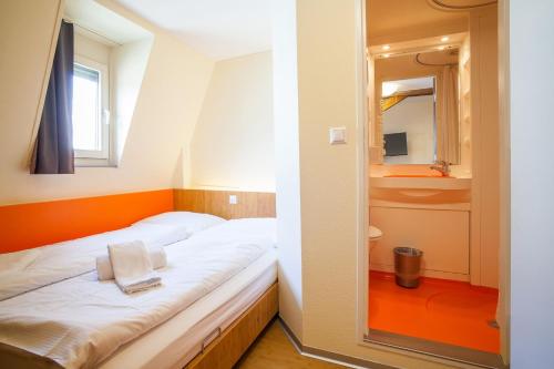 巴塞尔easyHotel Basel City - contactless self check-in的一间小卧室,配有一张床和镜子