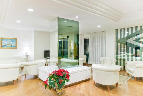 蒙特西尔瓦诺城市酒店的一个带浸泡浴缸和白色椅子的沙龙