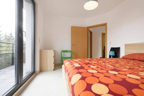 卢森堡卢森堡顶楼公寓酒店的一间卧室配有一张带橙色和白色毯子的床