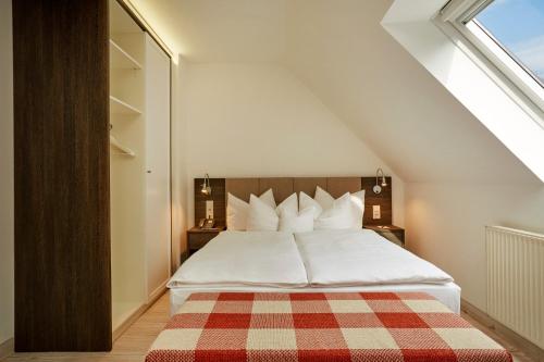 纽伦堡纽伦堡H+酒店 的一间卧室配有一张带 ⁇ 子毯子的床