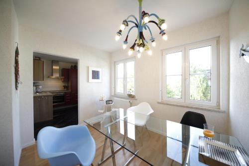 拜罗伊特Apartment Walküre的一间设有玻璃桌和白色椅子的用餐室