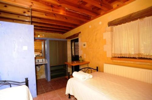 瓦莫斯Villa Alexandrou的一间带两张床的卧室和一间位于客房内的厨房
