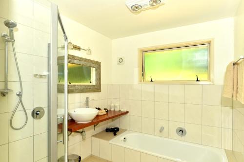 凯里凯里阿瓦隆度假村的带浴缸、水槽和窗户的浴室