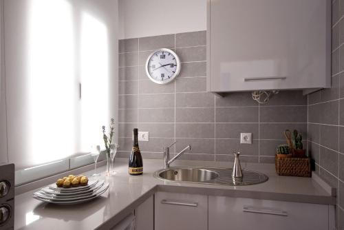 阿亚蒙特BeSlow Ayamonte的厨房配有水槽和墙上的时钟