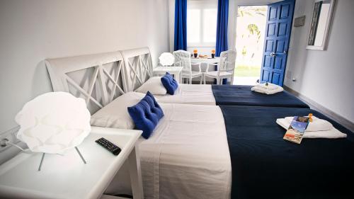 科拉雷侯Corralejo Lodge的一间卧室配有两张蓝色和白色的床