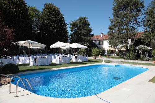 博沃伦塔卡萨乡村别墅酒店的一个带桌子和白色遮阳伞的游泳池