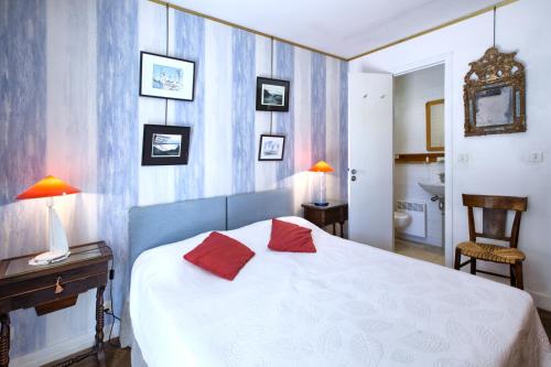 阿卡雄瑟普莱斯别墅的一间卧室配有一张带两个红色枕头的床