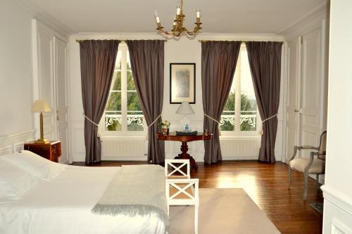 贝叶Clos de Bellefontaine B&B的卧室配有床、桌子和窗户。