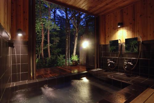 白马村番茄膳食山林小屋的一间带大窗户和水池的浴室