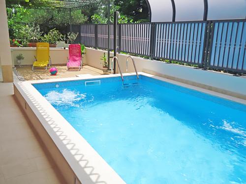 斯普利特马里安公园公寓的一个带两把草坪椅的游泳池和一个游泳池