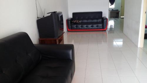 新邦波赖简单民宿的客厅配有黑色沙发和电视