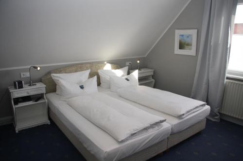 提努姆克里斯廷森酒店的卧室配有一张带白色床单和枕头的大床。