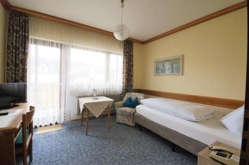 巴特欧波维德纳酒店的一间卧室配有一张床、一张沙发和一台电视