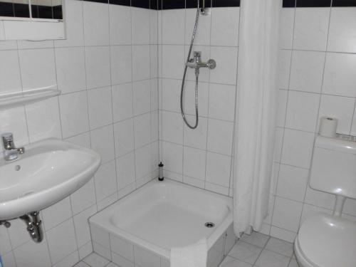 埃伯斯瓦尔德菲诺艾伯斯瓦尔德中心酒店的带淋浴和盥洗盆的白色浴室