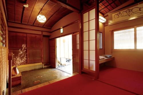 京都京都满月住宿加早餐旅馆的一个空房间,有门和窗户