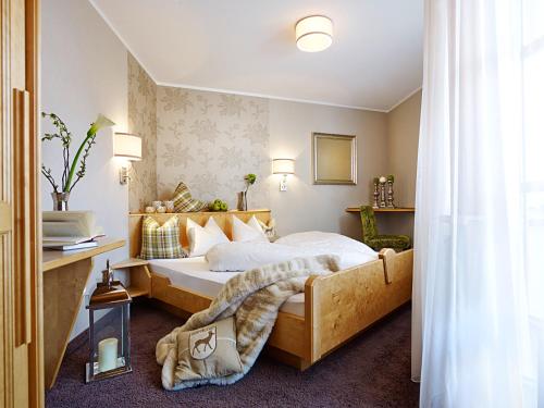 伊施格尔Apart Montanara的酒店客房配有一张床、一张书桌和一张四柱床