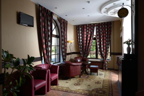 贝尔科维察德梅特拉家庭旅馆的一间设有红色椅子和窗户的等候室