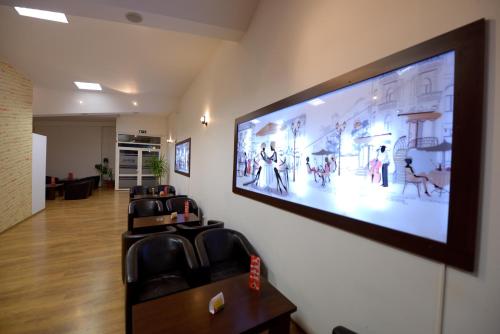TecuciHotel Sophia的一间墙上的大屏幕平面电视的等候室
