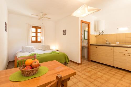 圣弗朗西斯科哈维尔Residence Can Confort Formentera的一间房间,配有一张床和一张桌子,还有一碗水果