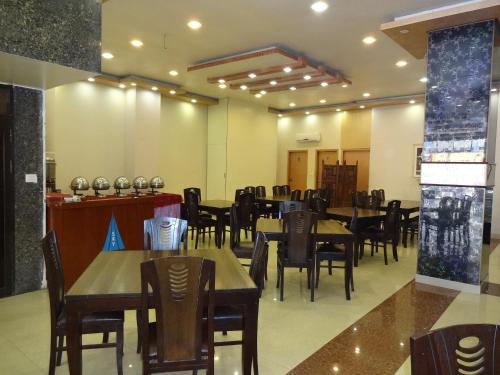 卡拉奇天空塔酒店的一间在房间内配有桌椅的餐厅