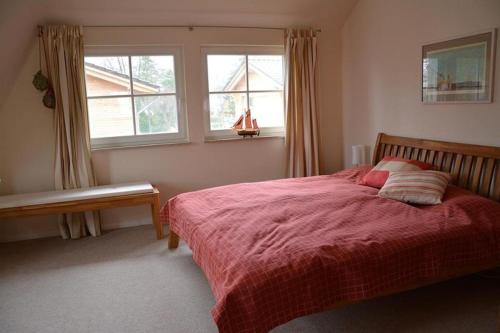 普雷罗Hagens Hus的一间卧室配有一张带红色毯子的床和窗户。