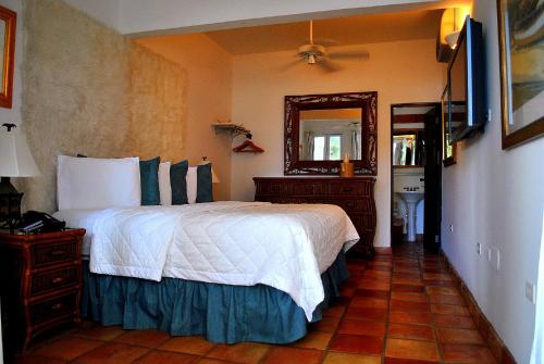 圣胡安相思精品酒店的一间卧室配有一张大床和镜子