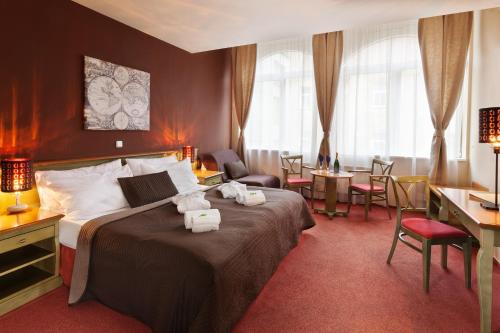 布拉格奥古斯托斯奥托酒店的酒店客房带一张床、一张桌子和椅子