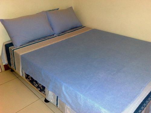 马尼拉爱丽舍城堡公寓式酒店的一张带蓝色床单和蓝色枕头的床
