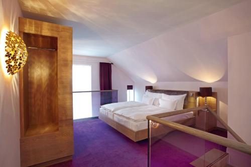 莱比锡阿比托套房酒店的一间卧室设有一张床,楼梯位于卧室内