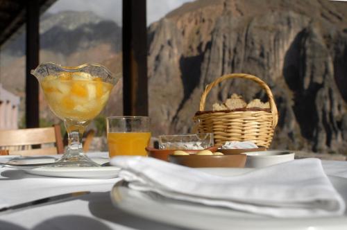伊鲁亚Hotel Iruya的一张桌子,上面放着一篮子的食物和一杯橙汁