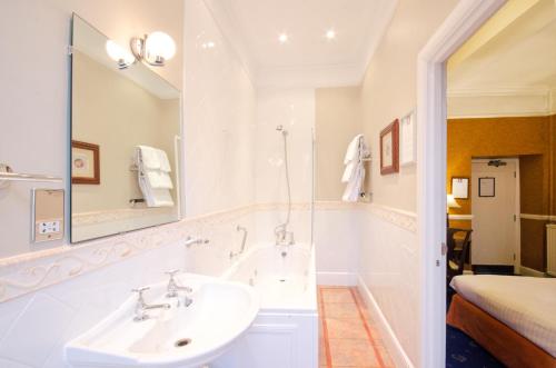 泰特伯里福克斯司农提酒店的白色的浴室设有水槽和镜子