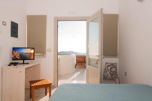 易莫洛林卡尔德拉马杰斯提别墅的一间卧室设有一张床、一台电视和一个窗口。