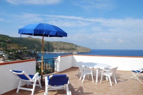 帕利努罗Residence Riviera的庭院配有桌椅和遮阳伞。