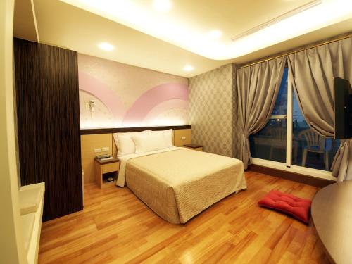 垦丁大街艾比莎渡假旅店二馆的一间卧室设有一张床和一个大窗户